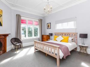 a bedroom with a bed and a chair at Beautiful villa in Napier with spa in Napier