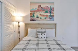 Un dormitorio con una cama y un cuadro en la pared. en 1 Best Location Cozy Apartment, en Los Ángeles