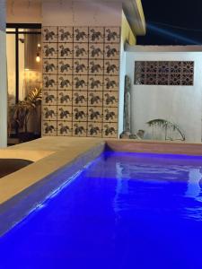 a swimming pool with blue lighting in a house at Punta Conejo Camila bungalows Surf Camp in Reparo