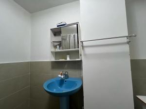 a bathroom with a blue sink and a mirror at Zebra Guest House in Ulaanbaatar