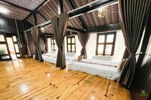 two beds in a room with wooden floors and windows at Eco green - Homestay & Hot spring Trạm Tấu in Trạm Tấu +65 photos