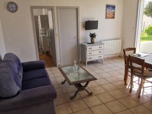 a living room with a blue couch and a table at Appartement cosy pour 2, centre-ville, proche plage, parking privé - FR-1-357-334 in La Tranche-sur-Mer