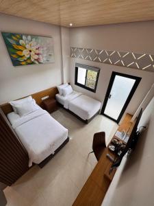 a large room with two beds and a desk at ABE Hotel & Convention in Siborongborong
