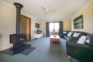 a living room with a couch and a wood stove at Miffys Cottage - Pet Friendly Getaway! in Allestree