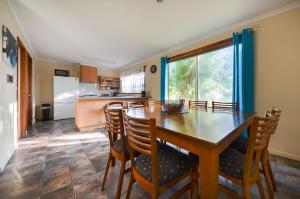 a kitchen and dining room with a wooden table and chairs at Miffys Cottage - Pet Friendly Getaway! in Allestree