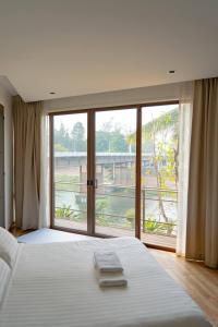 een slaapkamer met een bed en een groot raam bij Pool Villa Nam Nan in Nan