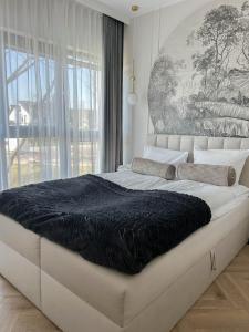 a large bed in a room with a large window at M&K Apartament Perła Sobieszewo - Wyspa Sobieszewska in Jazowa