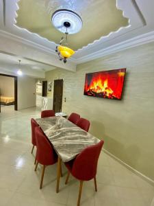 a dining room with a table and a fire on the wall at casa bella in Casablanca
