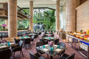 シンガポールにあるSheraton Towers Singapore Hotelのテーブルと椅子と滝のあるレストラン