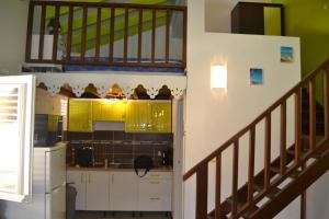 une cuisine avec des escaliers menant à un loft dans l'établissement Eden Kay, à Les Trois-Îlets