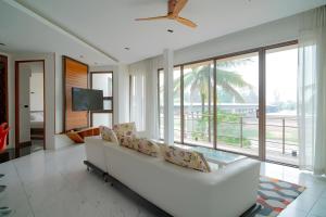 een woonkamer met een witte bank en een tv bij Pool Villa Nam Nan in Nan