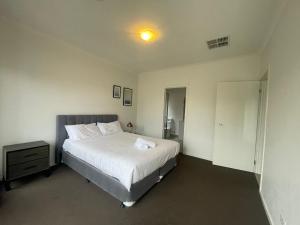 a bedroom with a bed and a light on the ceiling at Discover Luxury Living & Aviation History in Point Cook +9 photos