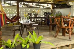 a dining room with tables and chairs and plants at A Plus Hometel - บ้านเอ๋ โฮมเทล in Phetchaburi