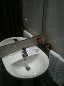 W łazience znajduje się biała umywalka i lustro. w obiekcie Hotel RC Ramon y Cajal w mieście Cuenca