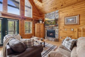 a living room with a fireplace in a log cabin at Cozy Cabin with views, hot tub, fishing pond, and game room in Sevierville