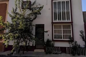 a white house with a tree in front of it at Little House Downtown Morelia in Morelia
