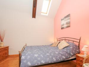 a bedroom with a bed with a blue comforter at Swallows Nest in Launceston