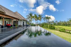 a villa with a pool in front of a house at Villa Rumah Lotus in Payangan
