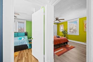 a bedroom with green and yellow walls and a bed at Cozy & Creative Top Unit in Lou's Arts District in Louisville