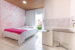a bedroom with a bed and a pink wall at POUSADA los SABABA in Morro de São Paulo