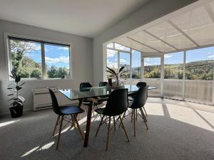 a dining room with a glass table and chairs at Lune Lux in Oamaru