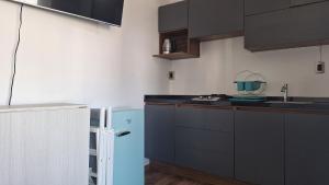 a kitchen with black cabinets and a blue refrigerator at Dpto Torre Brasil in Morelia