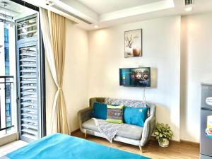 ein Wohnzimmer mit einer Couch und einem Fenster in der Unterkunft Walking Lake, Pool, Gym, Tennis & Volleyball Yard Delux Studio Apt in Hanoi + 92 Fotos