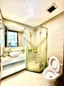 ein Badezimmer mit Dusche, Toilette und Waschbecken in der Unterkunft Walking Lake, Pool, Gym, Tennis & Volleyball Yard Delux Studio Apt in Hanoi