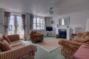 a living room with couches and a fireplace at Little Chequers in Friston