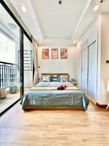 a bedroom with a large bed with blue pillows at Fully Furnished Studio, 5 Star Class Apt With Gym, Pools, Tennis Yard & Other Outdoor Sport in Hanoi +95 photos