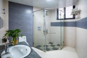 サパにあるGrand Flamant Sapa Central Hotelの洗面台とシャワー付きのバスルーム