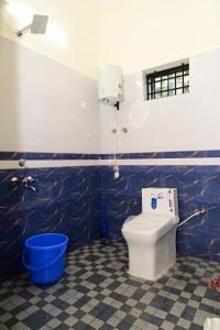 a bathroom with a toilet and a blue wall at George's Legacy Stay in Kāsarkod +22 photos
