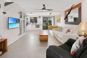 una sala de estar con un sofá y una mesa en Noosa Place Resort, en Noosaville