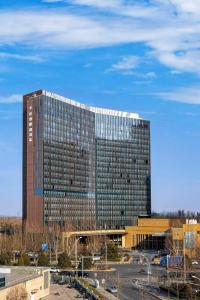un grand immeuble de bureaux avec beaucoup de fenêtres dans l'établissement Kun Tai Glory Hotel Beijing Wangjing, à Pékin