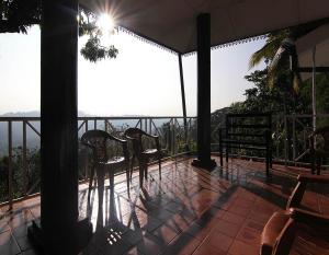 康提的住宿－康提二合一旅舍，阳台配有椅子,享有海景。