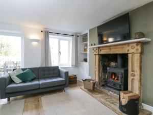 a living room with a couch and a fireplace at The Old School House in Lower Swell