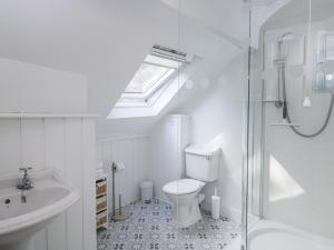 a bathroom with a toilet and a sink and a shower at The Old School House in Lower Swell +47 photos