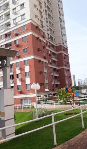 a tall apartment building with a fence in front of it at Apartamento de Luxo com Suíte, Academia, Piscina e Mercado in Cuiabá
