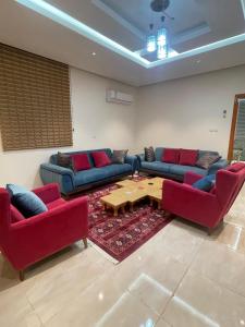 a living room with couches and a coffee table at RoseVilla روزفيلا in Ḩaql