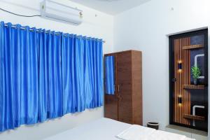 AlleppeySreeragam residency cherthala的一间卧室配有蓝色窗帘和窗户