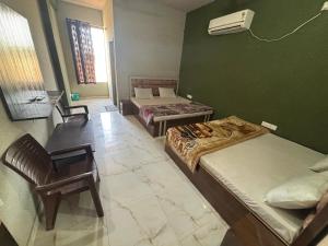 Una habitación con dos camas y una silla dentro. en Hotel Chandar Palace - Near Khatu Shyam Ji Temple, en Khātu