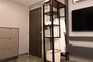 a room with a shelf with a tv and a closet at Cabanaz Pool Villa in Ban Zong Katiam