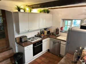 ヴェール・ポン・デュ・ガルにあるLe Mas de mon Pèreの白いキャビネットとコンロ付きオーブンを備えたキッチン