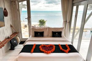 a bedroom with a bed with a heart made out of flowers at Honeymoon Villa Sea View - Nusa Penida in Nusa Penida +31 photos