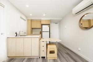 cocina con paredes blancas y armarios de madera en Sleek Braddon Apartment Near Canberra Centre - Hosted by Canstay, en Braddon 17 fotos más