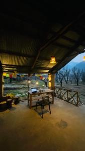 a patio with a table with a laptop on it at Summerwood farmhouse by rastafardreams in Katrain