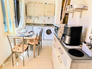 a kitchen with a table with chairs and a stove at "SARDESIDENCE" Spiaggia Privata WiFi Parcheggio Riservato in Costa Rei