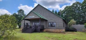 a house with a sign on the side of it at Greystone Lodge in Dullstroom