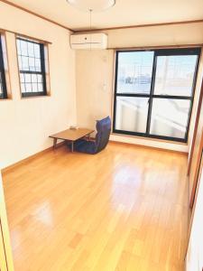 an empty room with a table and a large window at apartment hotel myu didymi in Utsunomiya +3 photos