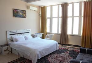 Shahr-e NowClock Tower Hotel的带床、沙发和窗户的卧室